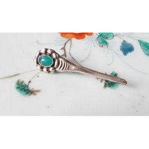 Sknvirke broche i slv med grn sten.   Ml: 4,5x1 cm.